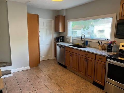 Kitchen showing newly installed paneled door to laundry and bath and updated staircase to add two more steps and landing. 