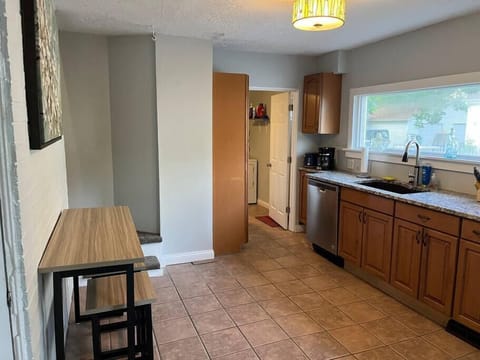 Kitchen from Front Door, with door leading to Laundry and Bathroom to the right and stairs going up to the left. 