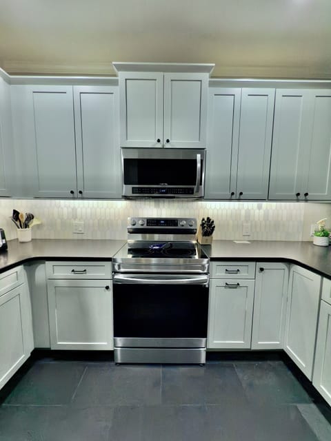 Stainless appliances and large dark granite countertops