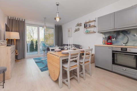 A modern kitchen with wooden cabinets, a built-in oven, and a stylish backsplash. It’s equipped with all necessary appliances for cooking.