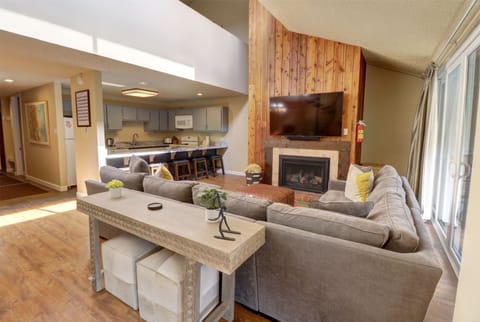 Living room features a large TV and fireplace.