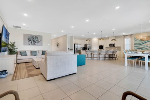 - Bright living room with cozy sectional and TV setup  
- Open floor plan connects kitchen and dining spaces  
- Perfect for family gatherings in a welcoming layout