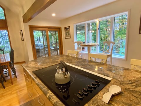 Open kitchen w/ bar & high top seating- sliding door access to second story deck