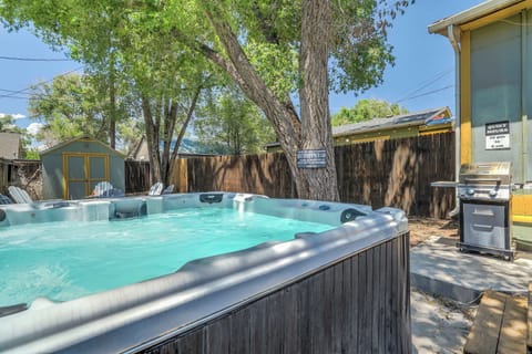 Unwind in the spacious hot tub under the shade of trees, perfect for relaxing after a day of adventure. Enjoy the BBQ grill nearby for outdoor dining!