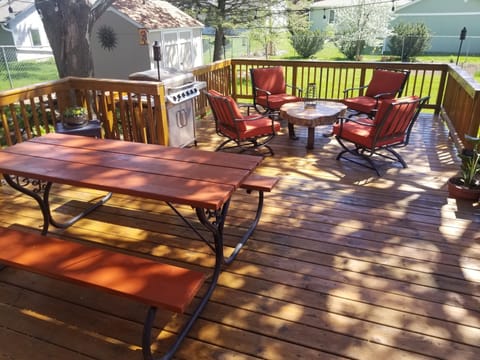 Shaded backyard deck with picnic table is great for barbecues.