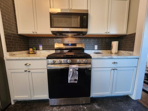 Self cleaning gas range with center griddle, microwave and counter space