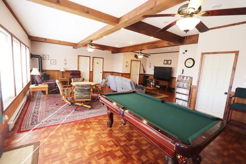 Large great room featuring slate pool table, card/game table, and 65" smart tv.
