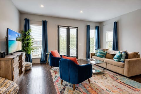 Bright and inviting living room with colorful seating and bold red accent pillows, perfect for relaxing and gathering.