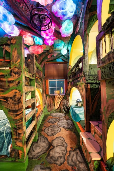 Downstairs bunk room. The forest canopy ceiling glows and shimmers with magical colors. Magical forest dreamscape: two queens and four XL twin beds. Plus a hobbit door! 