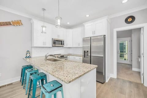 Fully stocked kitchen with pots and pans. Fridge has water/ice dispenser