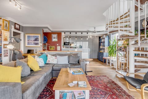 Living room with a large L shape sofa, coffee table, stairs to the Private rooftop garden, bookshelves full of books and Large Smart TV with Netflix.

you also have 4 large windows with panoramic views of the city and the best sunsets in Norwich.

In the corner, there is an indoor fireplace for romantic cosy evenings, we provide you with everything that you need to start a fire...