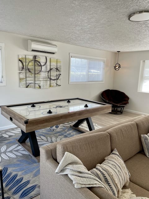 Bonus room with air hockey, pull out sofa, tv, desk and some extra chairs