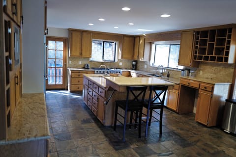 Gourmet kitchen with double ovens, gas rangetop, spacious countertops, & island