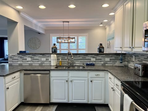 Spacious kitchen with upgraded countertops, backsplash, and appliances. 