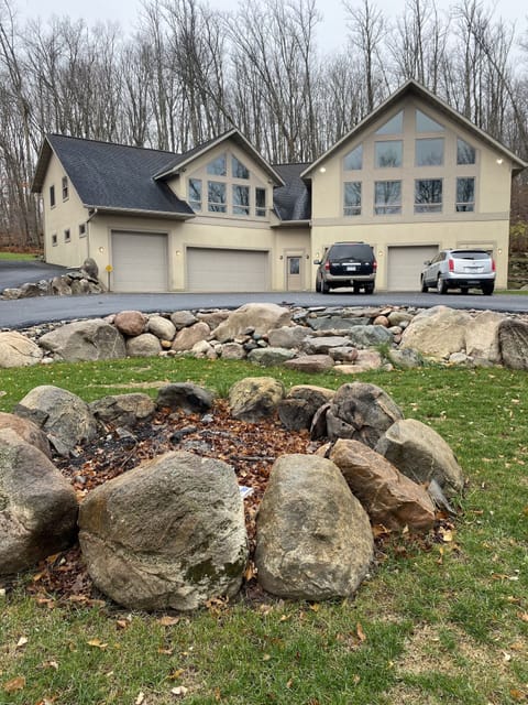 Huge firepit with detailed landscaping in front of house, yet cloaked in privacy