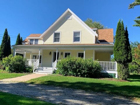 Large porch with outdoor dining table and various seating areas.