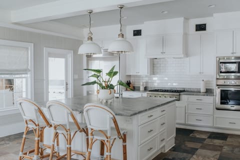 Kitchen view of island, bar stools and stove.