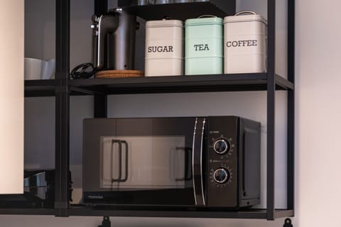 Kitchenette with plenty of kitchen utensils and dishes.