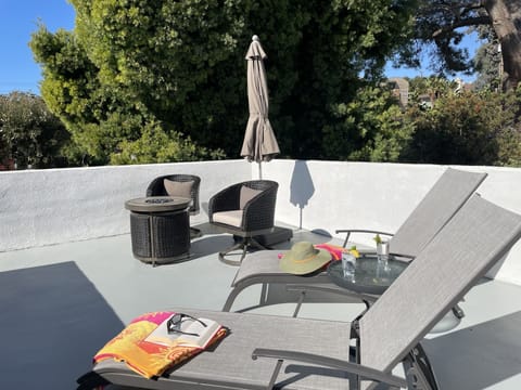 Private deck with fire pit table, chairs, sun umbrella and loungers. 