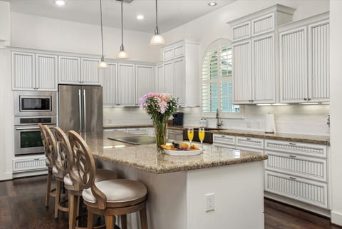 Chef's dream kitchen has massive granite island, induction cooktop, plate warmer, huge farmhouse sink & state of the art appliances.