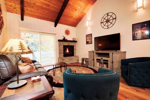 Living room with smart TV, gas fireplace leads to back patio.