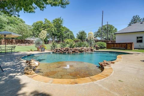 Oversized tanning ledge in pool with water features.