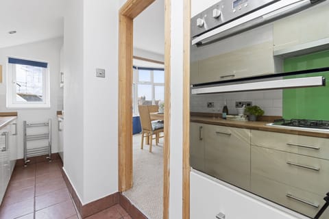 A modern, bright and airy galley style kitchen complete with cooking facilities, dishwasher, kettle and coffee machine. A washing machine and drier can also be found in the utility room