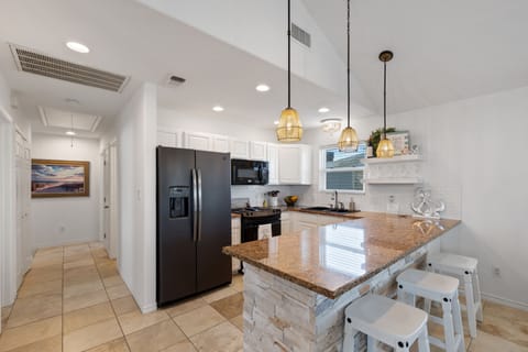 The kitchen is well-stocked and features a breakfast bar for quick meals.