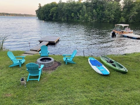 Relax by the water at Little Landing Cottage with Adirondack chairs around the fire pit, perfect for cozy evenings. Enjoy the convenience of a private dock for boating, along with kayaks and paddleboards for fun on Cobbosseecontee Lake.