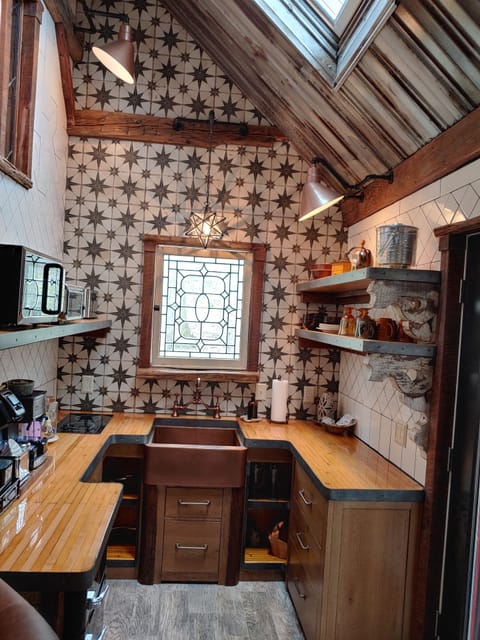 Kitchen with reclaimed bowling alley countertops, custom tiling and copper sink.