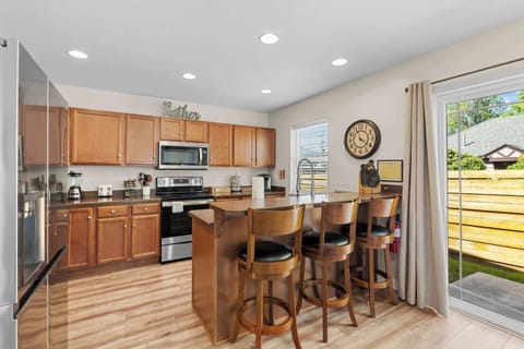 Full kitchen with island counter and bar stools.
