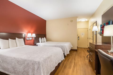 Unwind in a spacious double-queen room with warm lighting.