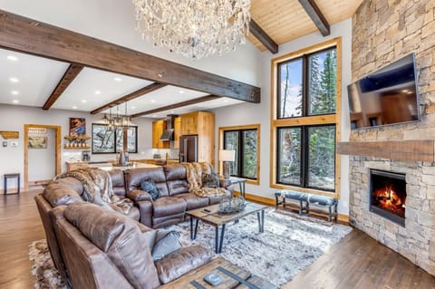 Relax on the luxury reclining sofa while enjoying the alpine views, gas fireplace, and HDTV with cable and streaming services underneath the light of the custom crystal chandelier.