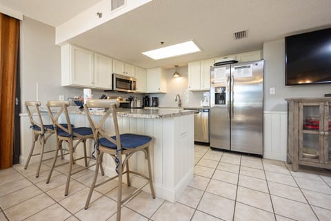 Modern kitchen featuring granite countertops, sleek cabinetry, coffee station, and bar seating for a relaxed dining vibe