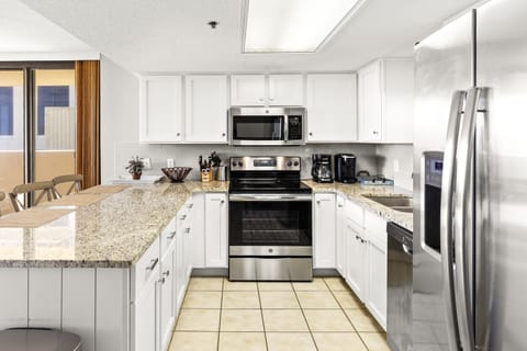 Bright kitchen features granite countertops, stainless appliances, and a breakfast bar with seating for casual dining