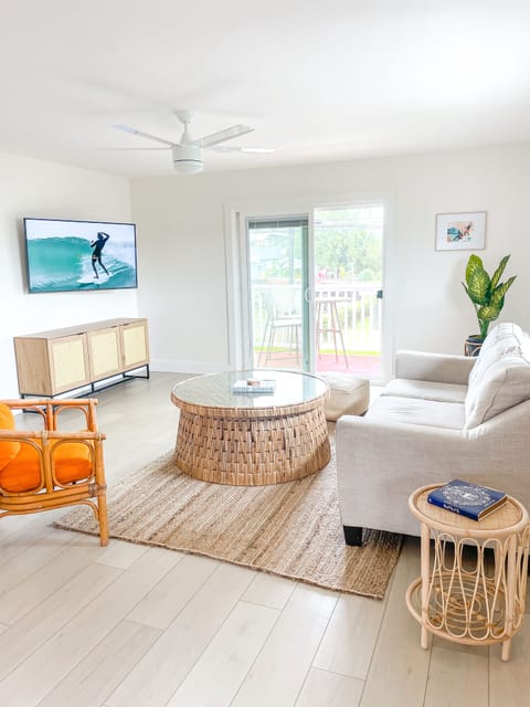 Spacious and airy living room with smart TV, huge sectional couch, and a lanai