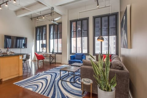 Relax in this cozy, modern living room featuring chic décor, comfortable seating, and warm lighting that creates the perfect ambiance for unwinding in the heart of downtown Fort Worth.