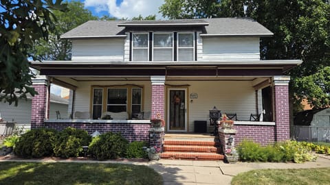 Front- Day: Historic open porch offers sunlit seating & space to gather/unwind.