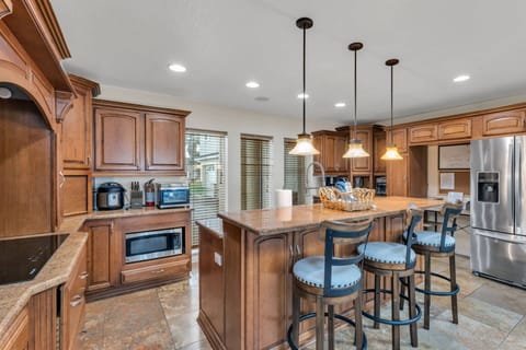 Fully equipped gourmet kitchen with custom wood cabinetry, granite countertops, and ample space for cooking meals together.