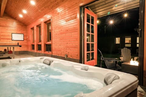 Indoor hot tub that opens to the outdoors.