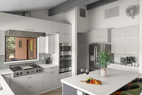 This stunning chef’s kitchen is the heart of the home—complete with sleek appliances, a spacious island with stylish seating, and forest views through the window. Ideal for cooking, gathering, and making lasting memories together.