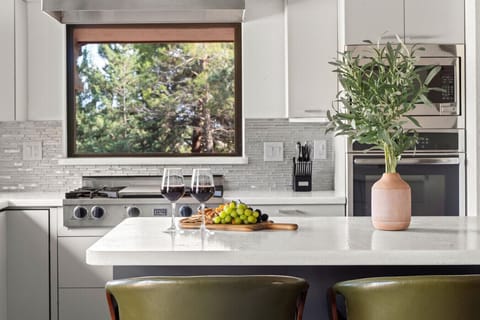 Savor wine and snacks at this stunning kitchen island with forest views framed perfectly by the window. With modern finishes and inviting seating, it’s the ideal spot to unwind and connect over great food and conversation.