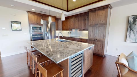 Large kitchen island with additional seating at the island and wine storage