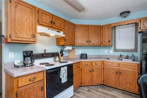 Stove, coffee station, toaster, sink and plenty of cabinets