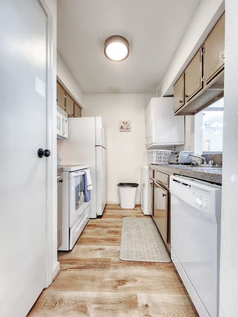 The functional kitchen includes a stove, toaster, coffee machine, and dishwasher