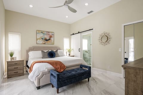 Primary bedroom with en-suite bathroom and pool views. 