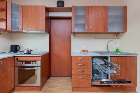 Fully equipped kitchen with wooden cabinetry, a stove, and ample counter space.
