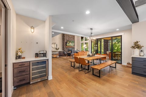 Expansive dining space with fireplace views, oversized windows, and beverage station nearby