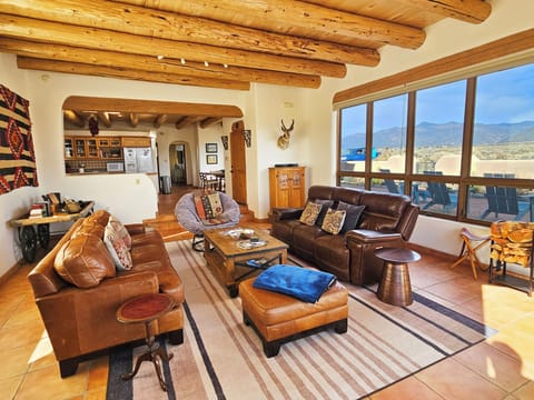 Great room with interior views and exterior views towards Valdez.  Large electric recliner couch and cabinet of games.