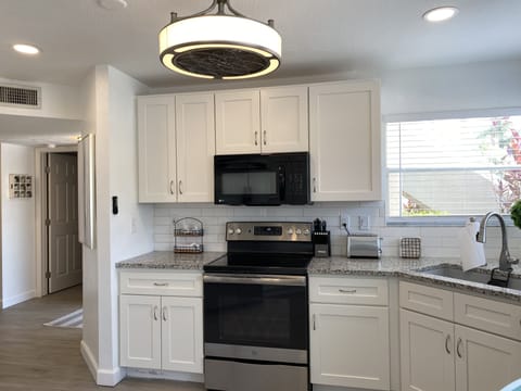 Kitchen with new cabinets, stainless steel appliances and granite countertops.